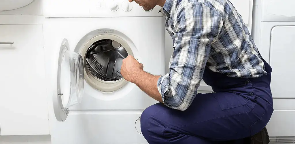 Handyman inspecting a dryer drum and internal parts for repair in Tuscaloosa, AL