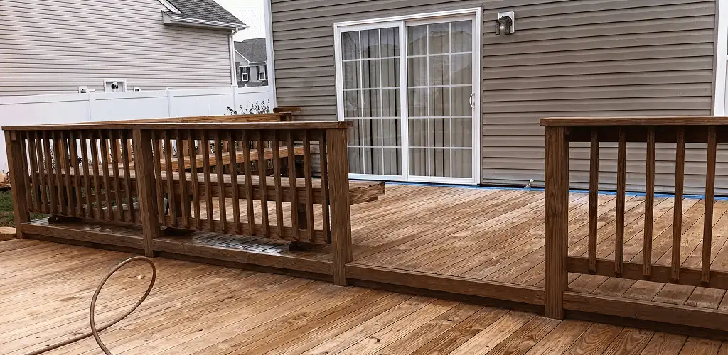Deck sealing service protecting a backyard wood deck and railings in Tuscaloosa, AL