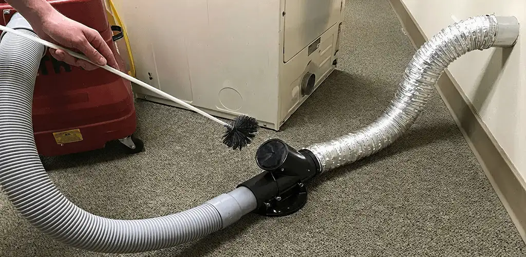 Dryer vent cleaning service removing lint from a dryer duct connection in Tuscaloosa, AL
