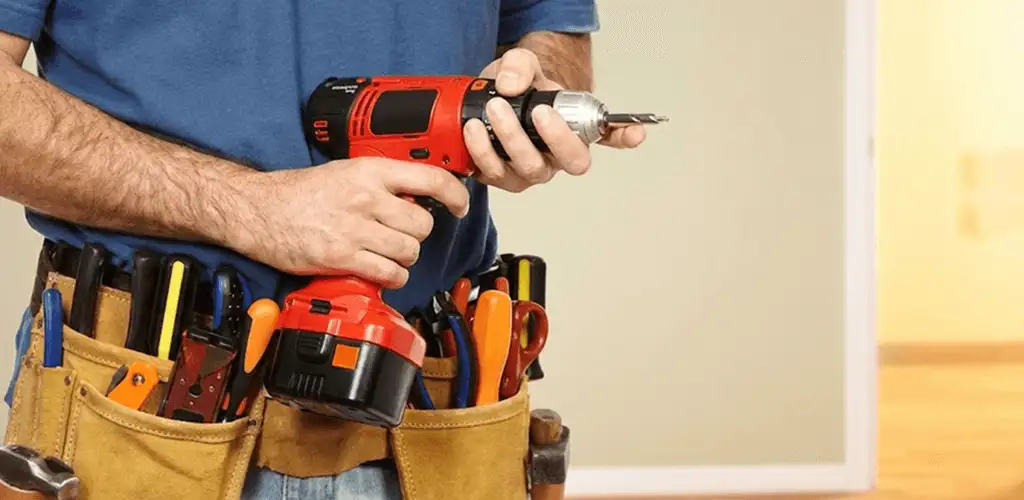 Handyman holding a power drill for home repairs and installations in Tuscaloosa, AL