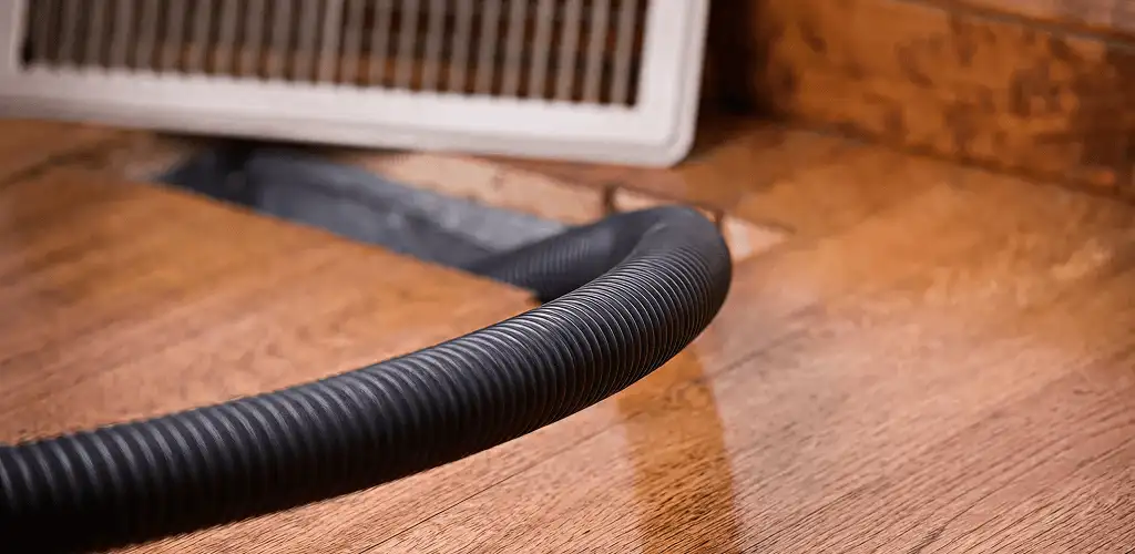 Air duct cleaning hose inserted into a floor vent for ductwork cleaning in Tuscaloosa, AL