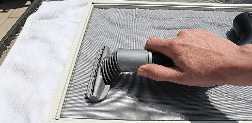 Window screen repair cleaning and fixing a damaged screen mesh in Tuscaloosa, AL